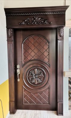 a wooden door with ornate carvings on the front and side panels, in a room