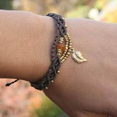 a close up of a person's arm wearing a bracelet with beads and charms