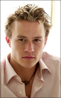 a young man with curly hair wearing a shirt and tie