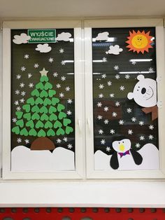 two windows decorated to look like christmas trees and snowflakes with animals on them