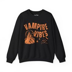 Sink your teeth into Halloween fashion with the Eddy and Rita Women's Heavy Crewneck Sweatshirt featuring the phrase "Vampire Vibes" in a spooky, stylish design. This heavyweight sweatshirt provides maximum warmth and comfort, making it perfect for those crisp autumn nights. With its relaxed fit, this sweatshirt is ideal for layering over your favorite Halloween ensemble or wearing solo for a cozy night in. Whether you're hitting a Halloween party, trick-or-treating, or just enjoying the season, Halloween Streetwear Sweatshirt With Letter Print, Halloween Letter Print Sweatshirt For Streetwear, Black Halloween Punk Sweatshirt, Black Punk Style Halloween Sweatshirt, Black Punk Sweatshirt For Halloween, Black Punk Style Sweatshirt For Halloween, Black Grunge Sweatshirt For Halloween, Black Gothic Sweatshirt For Halloween, Black Gothic Sweatshirt With Graphic Print