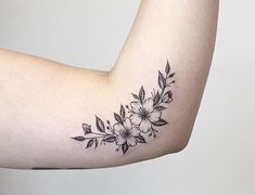 a woman's arm with black and white flowers on it