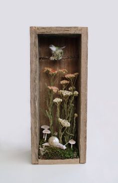 a wooden box filled with flowers and mushrooms