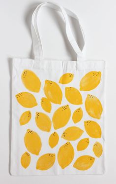 a white bag with yellow lemons painted on it