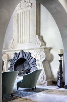 a living room filled with furniture and a fire place in the middle of an archway