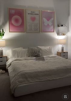 a white bed sitting in a bedroom next to two pictures on the wall above it