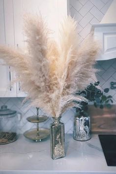 there is a vase with some flowers in it on the counter top next to other items