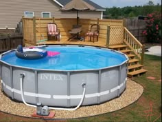 an above ground swimming pool in a backyard with deck and patio furniture on the side