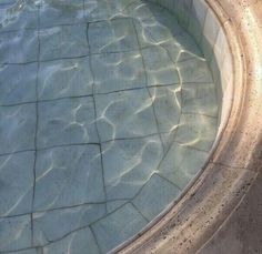 an empty swimming pool with no people in it and water reflecting off the floor to the side