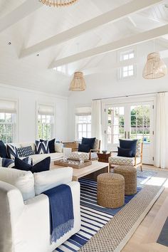 a living room with white furniture and blue accents