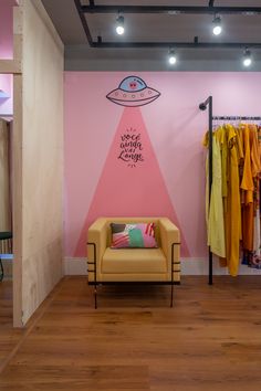 a room with pink walls and a yellow chair in front of a wall that has an advertisement on it