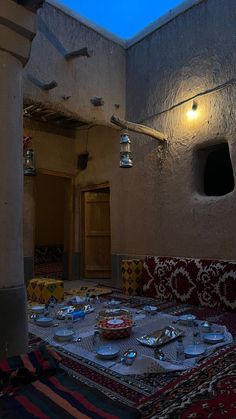 a table is set up in the middle of a room with many plates and silverware on it