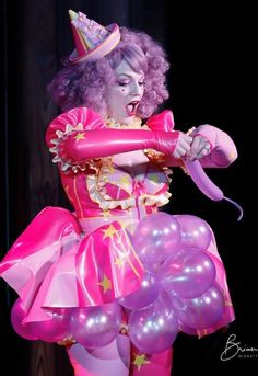 a woman dressed as a clown with balloons