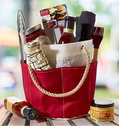 a red bag filled with wine bottles and other items sitting on top of a wooden table