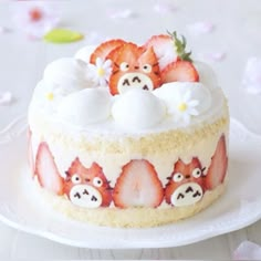 a cake decorated with strawberries and white frosting on a plate next to flowers