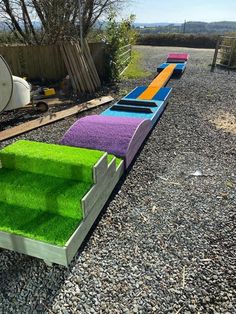 a train made out of fake grass sitting on top of gravel