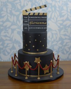 a three tiered cake decorated with black and gold stars