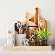 the kitchen utensils are organized in a wooden tray