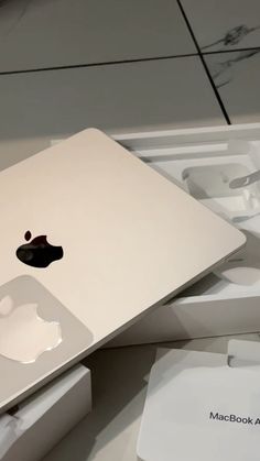 an apple macbook air sitting on top of a white box next to other boxes