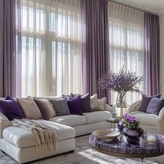 a living room filled with furniture and purple curtains