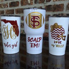 three personalized tumblers sitting next to each other in front of a brick wall