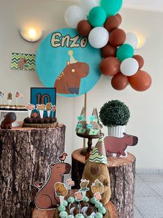 there are many decorations on the tree stumps in this birthday party decoration set up