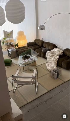 a living room filled with lots of furniture next to a wall mounted light above it