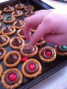 a hand is picking up some chocolate covered pretzels