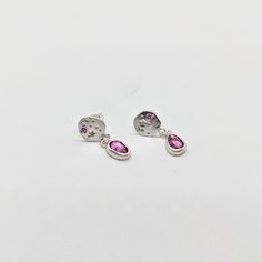 These gorgeous dangling earrings feature and handmade starry silver disk with one pink sapphire set on each side and a beautiful garnet that sparkles on the bottom. Each earring is handmade and therefore unique and will differ from one an other. ✨ Silver care - the studs of these earrings are made with sterling silver and may cause an allergic reaction in people sensitive to metal. Silver is easy to care for, avoid contact with water, and polish with light jewelry cloth or mild jewelry cleanser Pink Birthstone Drop Earrings, Pink Sapphire Round Earrings As Gift, Pink Sapphire Earrings As A Gift, Sterling Silver Pink Birthstone Earrings, Pink Sterling Silver Birthstone Earrings, Pink Birthstone Earrings In Sterling Silver, Pink Garnet, Light Jewelry, Allergic Reaction