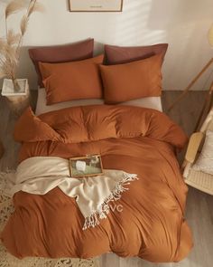 an orange comforter and pillows in a bedroom