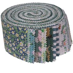 a roll of multicolored fabric with flowers and leaves on the bottom, in various colors