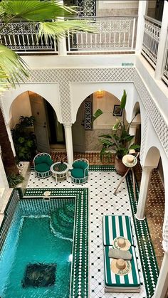 an indoor swimming pool in the middle of a building with white and green tiles on it