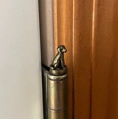 a metal door handle with a cat figurine on it