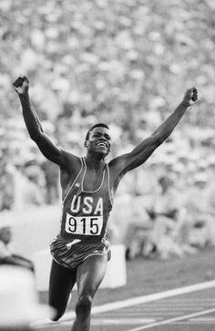 a man running on a track with his arms in the air