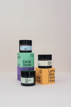 three jars of facial scrub sitting next to each other on a white surface with the words facial scrub written below them