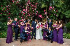 a group of people standing next to each other in front of flowers and petals on the ground