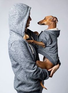 a woman holding a small dog in her arms