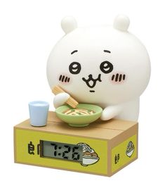 an alarm clock with a white bear holding a green bowl and chopstick in front of it