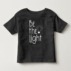 Christian Be The Light Funny Inspirational Toddler T-shirt Unisex Black Cotton T-shirt, Unisex Black T-shirt In Ring-spun Cotton, Black Short Sleeve T-shirt In Ring-spun Cotton, Unisex Black Ring-spun Cotton T-shirt, Black Short Sleeve Top In Ring-spun Cotton, Black Ring-spun Cotton Short Sleeve Top, Unisex Basic Black T-shirt, Basic Unisex Black T-shirt, Black Cotton T-shirt With Slogan