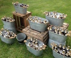 several buckets filled with beer sitting on top of a wooden pallet in the grass