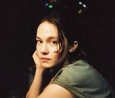 a woman sitting down with her hand on her chin