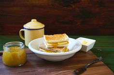 there is a bowl of food on the table next to a jar of mustard and a spoon