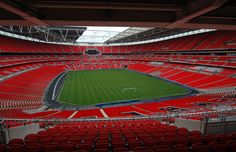 an empty soccer stadium with red seats