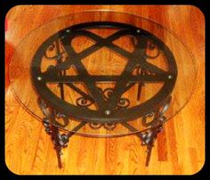 a glass table topped with an inverted pentagram on top of a wooden floor next to a hardwood floor