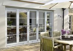 an outdoor dining area with table, chairs and umbrella in front of the patio door