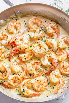 a skillet filled with shrimp and grits on top of a white countertop