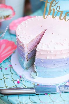 there is a cake that has been cut into pieces and sits on a table with other desserts