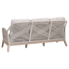 a white wicker couch sitting on top of a wooden table