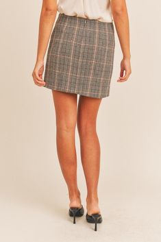 The Aretta Plaid Mini Skirt will be your go-to from day to night. Crafted from a soft wool-blend, this timeless plaid design features an asymmetric hem and statement tartan pattern. The ideal piece for stylish winter looks. Embrace your academic side in this dark, academia-inspired skirt. You'll be able to create so many aesthetically pleasing looks in this skirt, ranging from dark academia to 2000s posh. Crafted with luxurious details, like the front and back pleats, and a comfortable, high-wai Houndstooth Mini Skirt For Fall, Fall Plaid Mini Length Bottoms, Plaid Lined Skirt For Workwear, Plaid Skirt For Work In Fall, Plaid Skirt For Fall Workwear, Trendy Plaid Skort For Fall, Plaid Relaxed Work Skirt, Fall Plaid Lined Skort, Chic Plaid Mini Skirt Bottoms