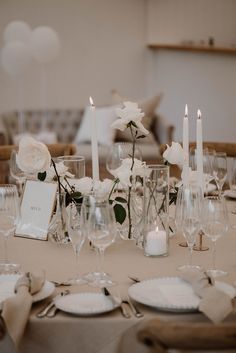 the table is set with candles, plates and napkins for an elegant wedding reception